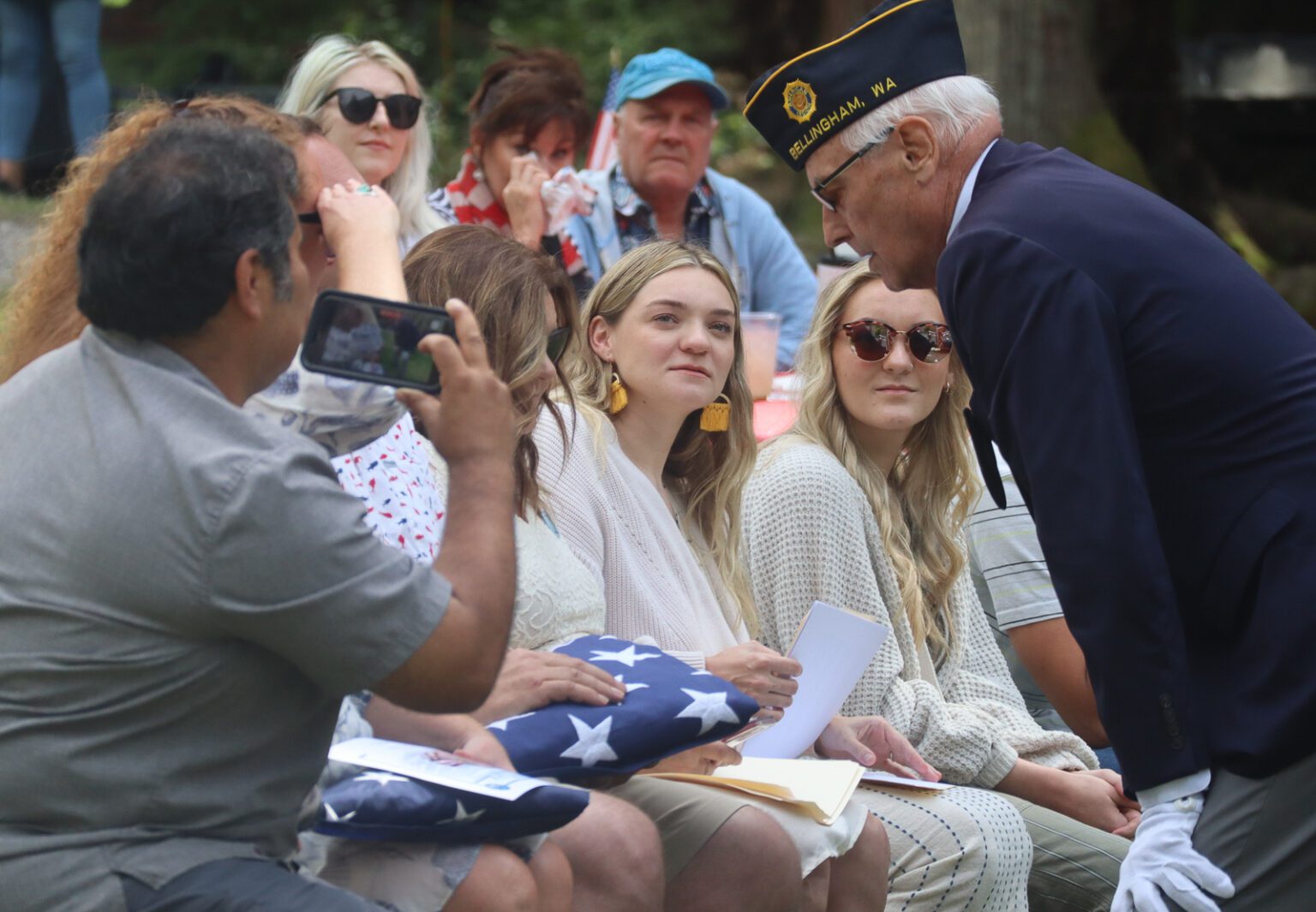 A member of the American Legion veterans organization speaks to the family of Buddy Fritz Partridge Jr. during the celebration of life ceremony on July 2 at Larrabee State Park. Several veterans groups presented flags and spoke with the family during the ceremony after the 21-gun salute and the playing of "Taps."