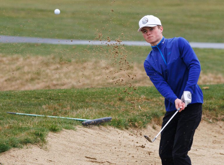 Lynden Christian’s Griffin Dykstra hits out of a bunker March 20 as Squalicum