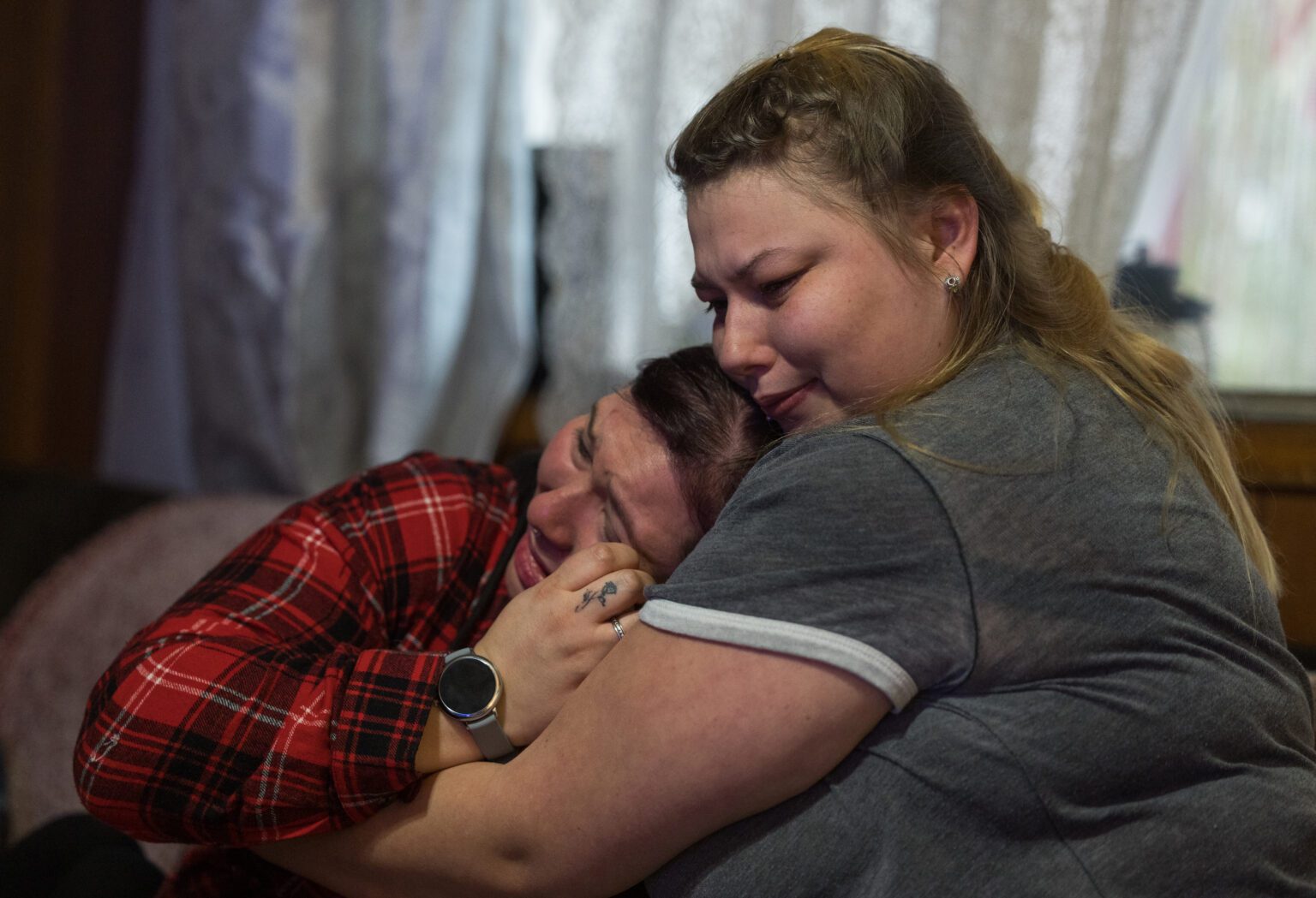 Alyshia Losey, left, is hugged by younger sister Elizabeth Babcock.