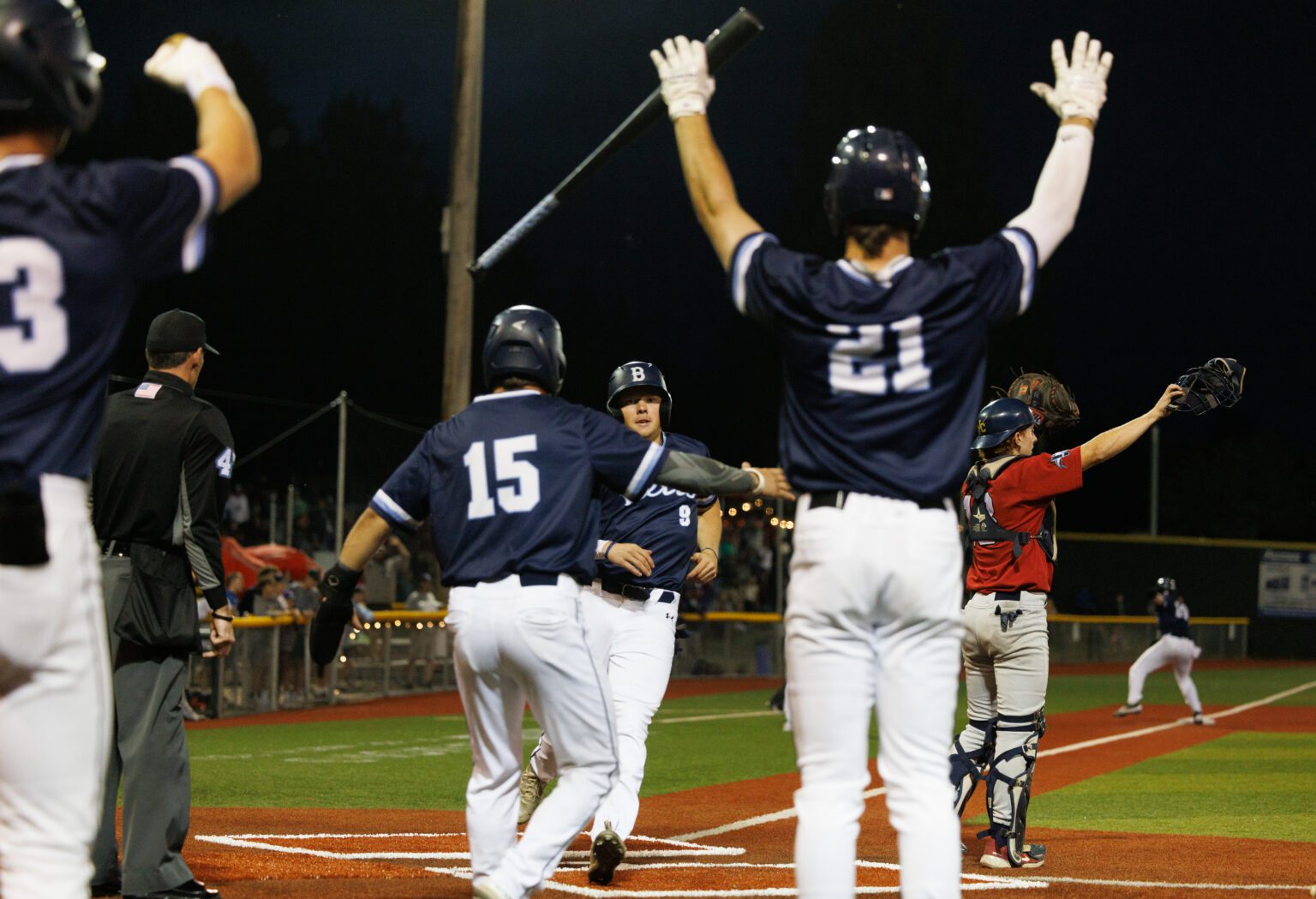 Bellingham Bells players celebrate after Jaidon Matthews (15) and Noah Meffert (9) cross home plate to put the Bells ahead in the eighth inning. The Bells beat the Victoria HarbourCats 4-2 in a West Coast League playoff game at Joe Martin Stadium on Aug. 10.