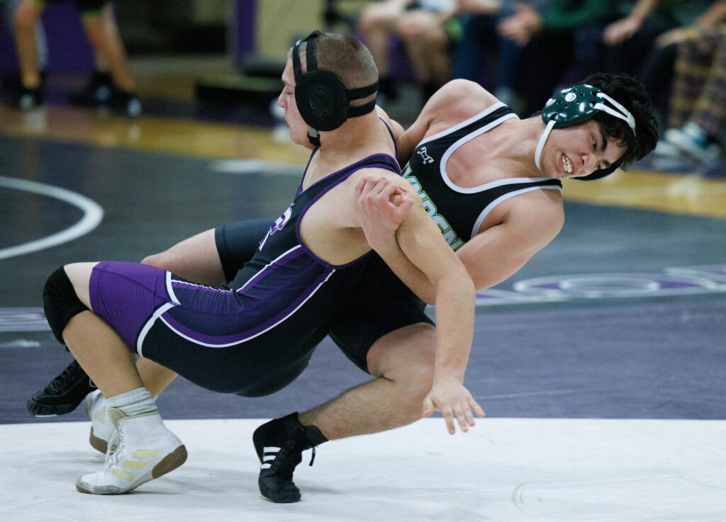 Lynden's Carlos Nava takes down Nooksack Valley’s Shane Stap to the mat by grabbing him from the back.