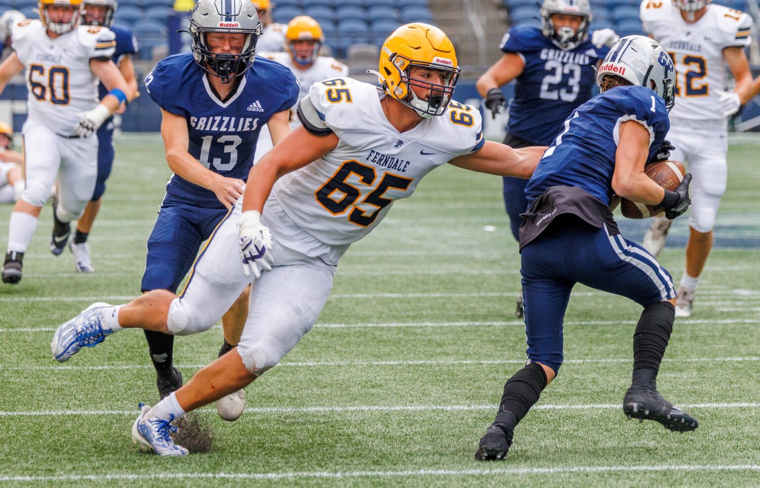 Ferndale's Jake Mason (65) grabs the Glacier Peak quarterback's side in an attempt to take control of the ball as other players rush over to help.