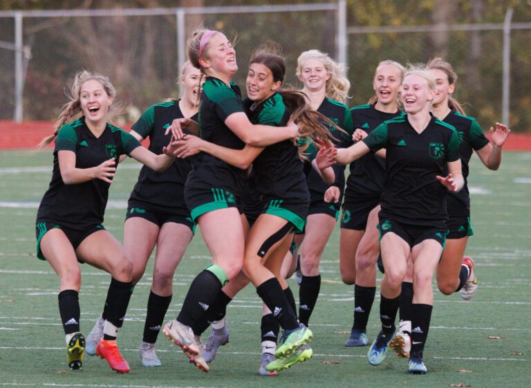 Lynden players celebrate after Maliah Mitchell’s kick gives the Lions the 2022 2A District 1 girls soccer title
