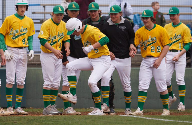 Lynden players watch as Lane Simonsen stomps on home plate after hitting a three-run homer April 21 in a game against Meridian.