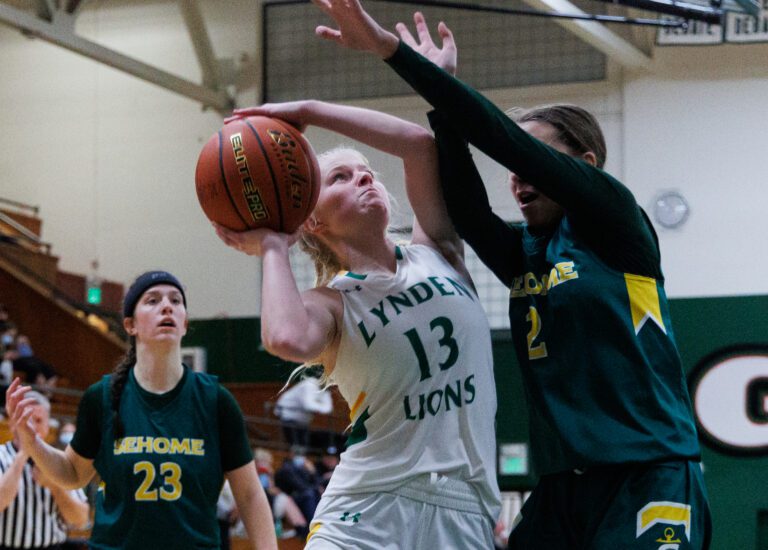 Lynden's Adia Newcomb makes a basket as Sehome's Madi Cooper defends in Lynden’s win over Sehome 43-34 at Mount Vernon High School on Feb. 17.