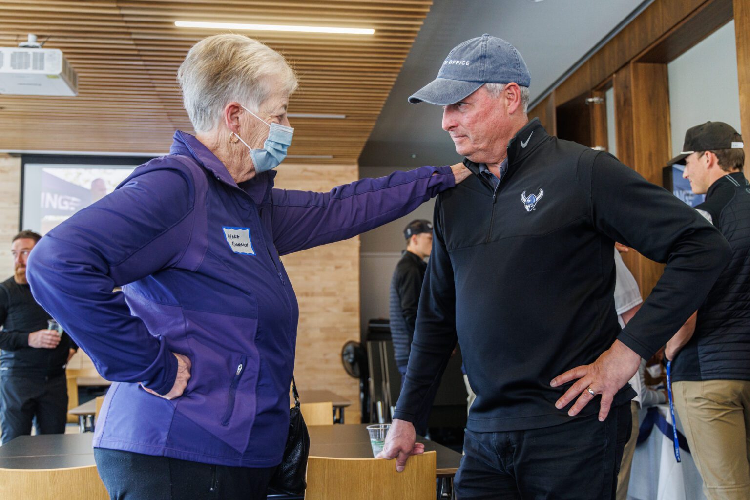 Former athletic director Lynda Goodrich puts a hand on the shoulder of now-retired Western Washington University athletic director Steve Card March 30 during his retirement celebration in the WWU Athletic Hall of Fame room. Card
