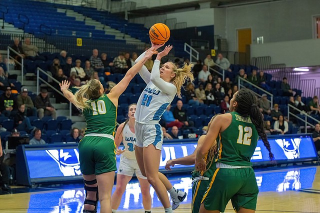 Western Washington University sophomore Truitt Reilly goes up for a shot as defenders surround and attempt to block the shot.