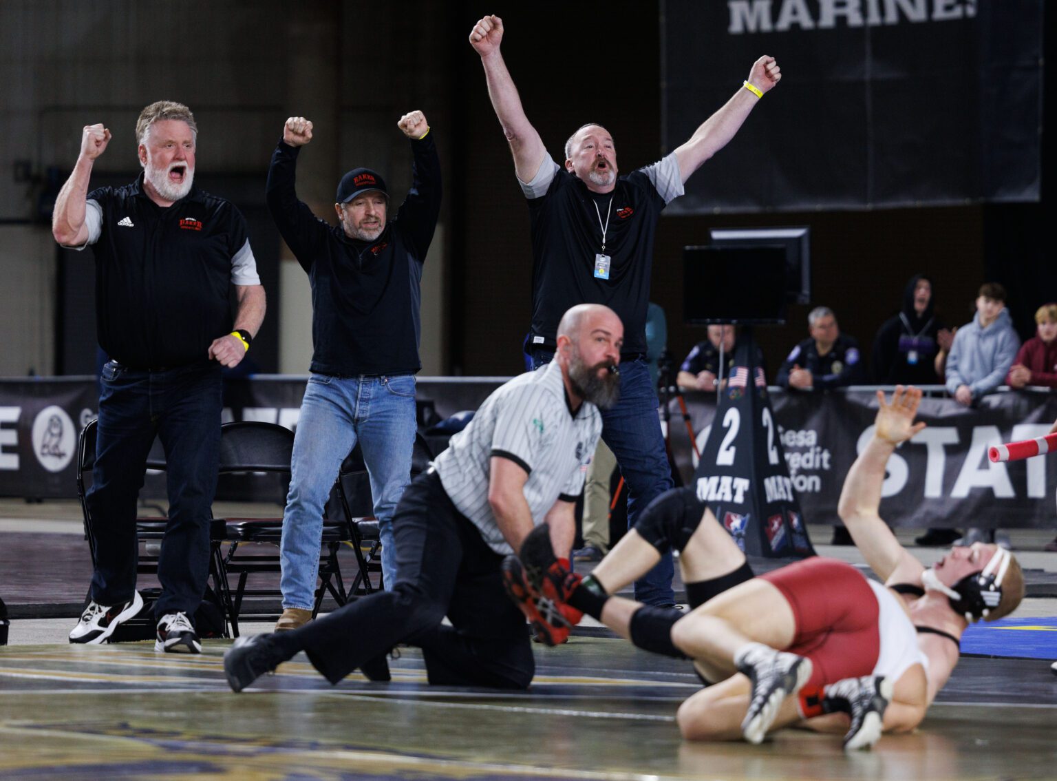 Mount Baker wrestling coaches celebrate after senior Elijah Washburn pins Toppenish's Amando Johns to win the Class 1A boys 170-pound state championship Feb. 18 at Mat Classic XXXIV at the Tacoma Dome.