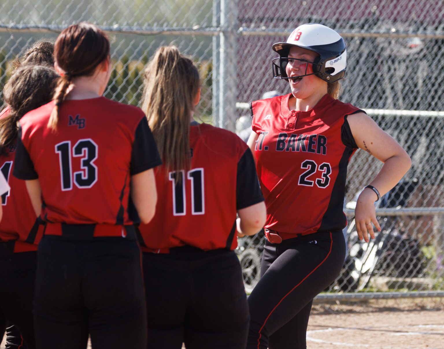 Mount Baker’s Ava Jeretsky meets her teammates at home plate after hitting a three-run home run April 28 as the Mountaineers beat Nooksack Valley 31-8 in four innings at Nooksack Valley Middle School.