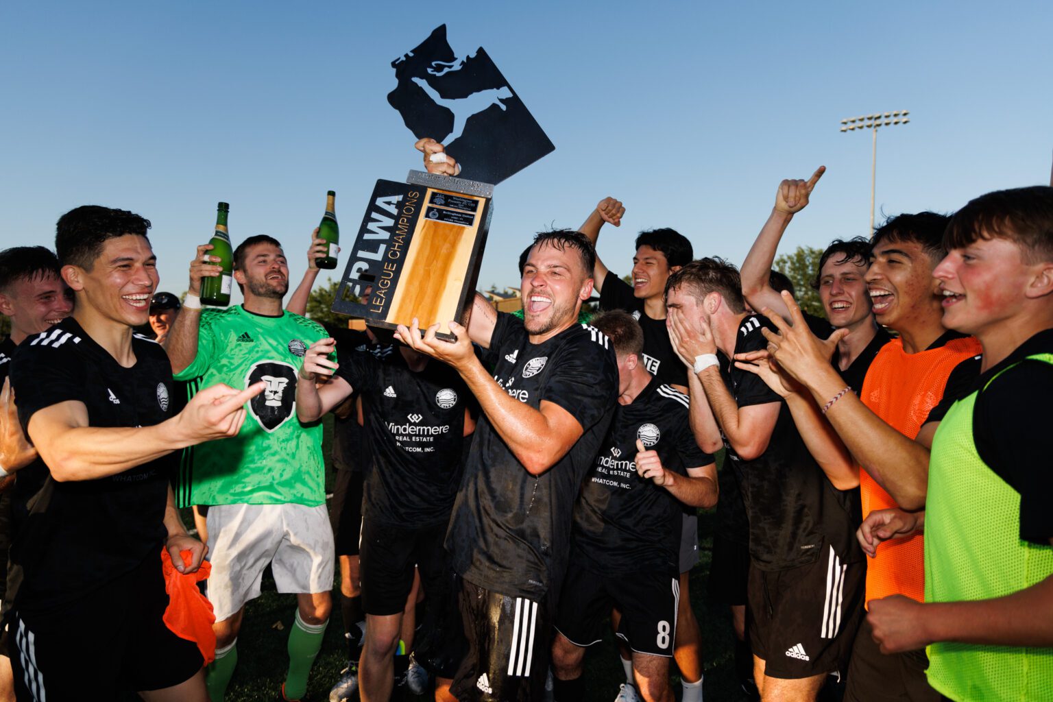 Dylan Langei holds up the trophy as Bellingham United FC celebrates its 3-2 win over Washington Premier in the Evergreen Premier League championship match July 23.