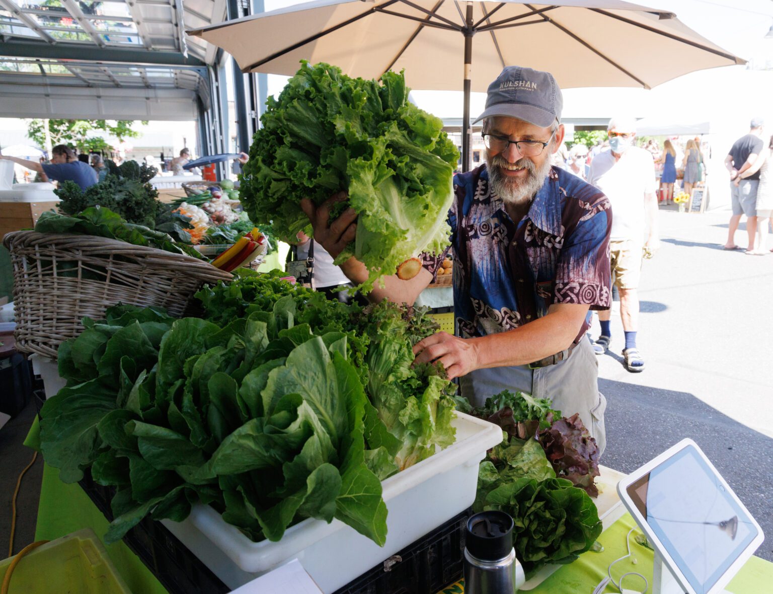 Cedarville Farms’ Mike Finger stocks more leaf lettuce in his booth at the Bellingham Farmers Market on July 30