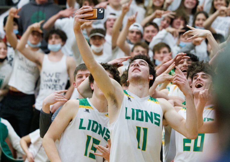 Lynden’s Jordan Medcalf takes a selfie with teammates and students after Lynden beat Sehome for the district championship.