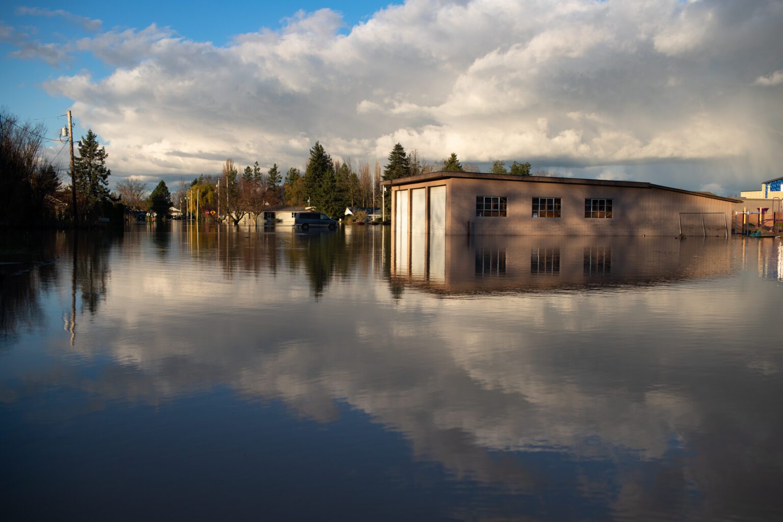 Water floods the street in front of Sumas Elementary School during the November 2021 floods. Thousands of properties were damaged across the region