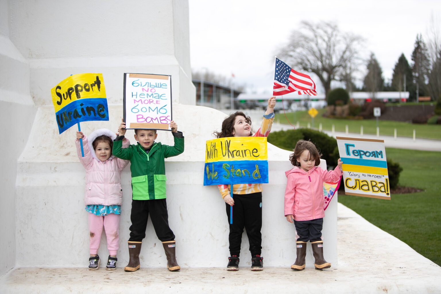 Ukrainian-American children stand on the Peace Arch with signs of support for Ukraine during a rally on Feb. 27.