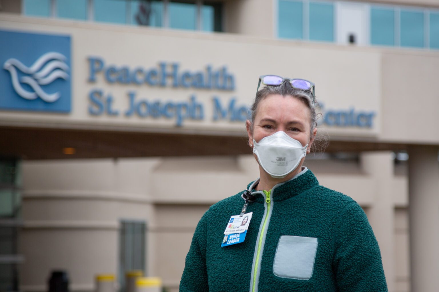 Cedar Anderson standing in front of the hospital wearing a mask.