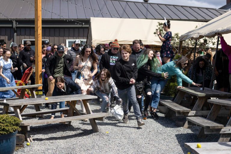 A crowd rushes into the Gruff Brewing beer garden to hunt for eggs at the brewery's adults-only Easter egg hunt on April 17. The eggs were filled with candy and sometimes numbers that corresponded to prizes inside.