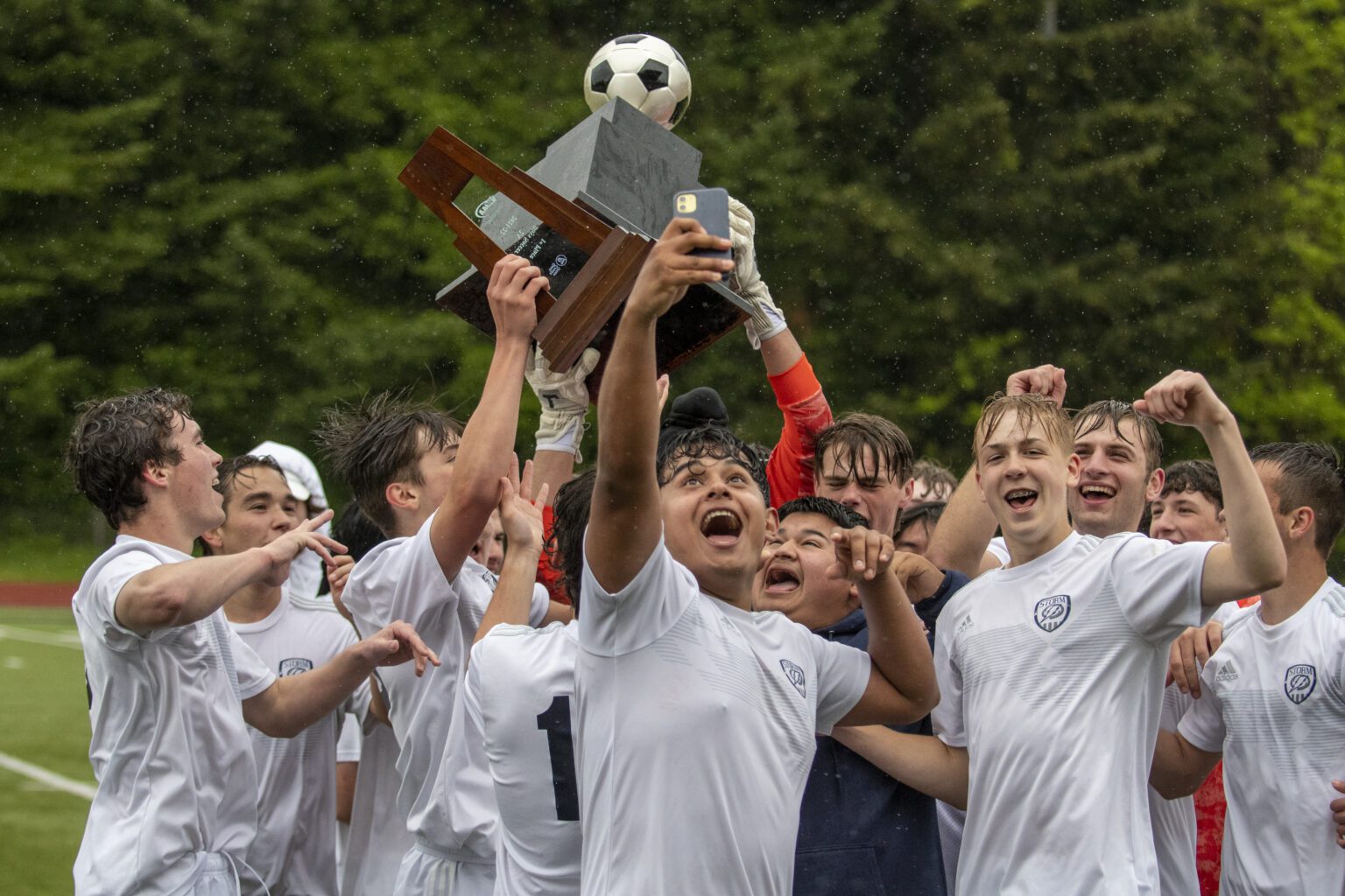 Squalicum boys soccer players celebrate while holding the 2A state championship trophy after defeating Burlington-Edison 5-0 in the title game in Tumwater on May 28.