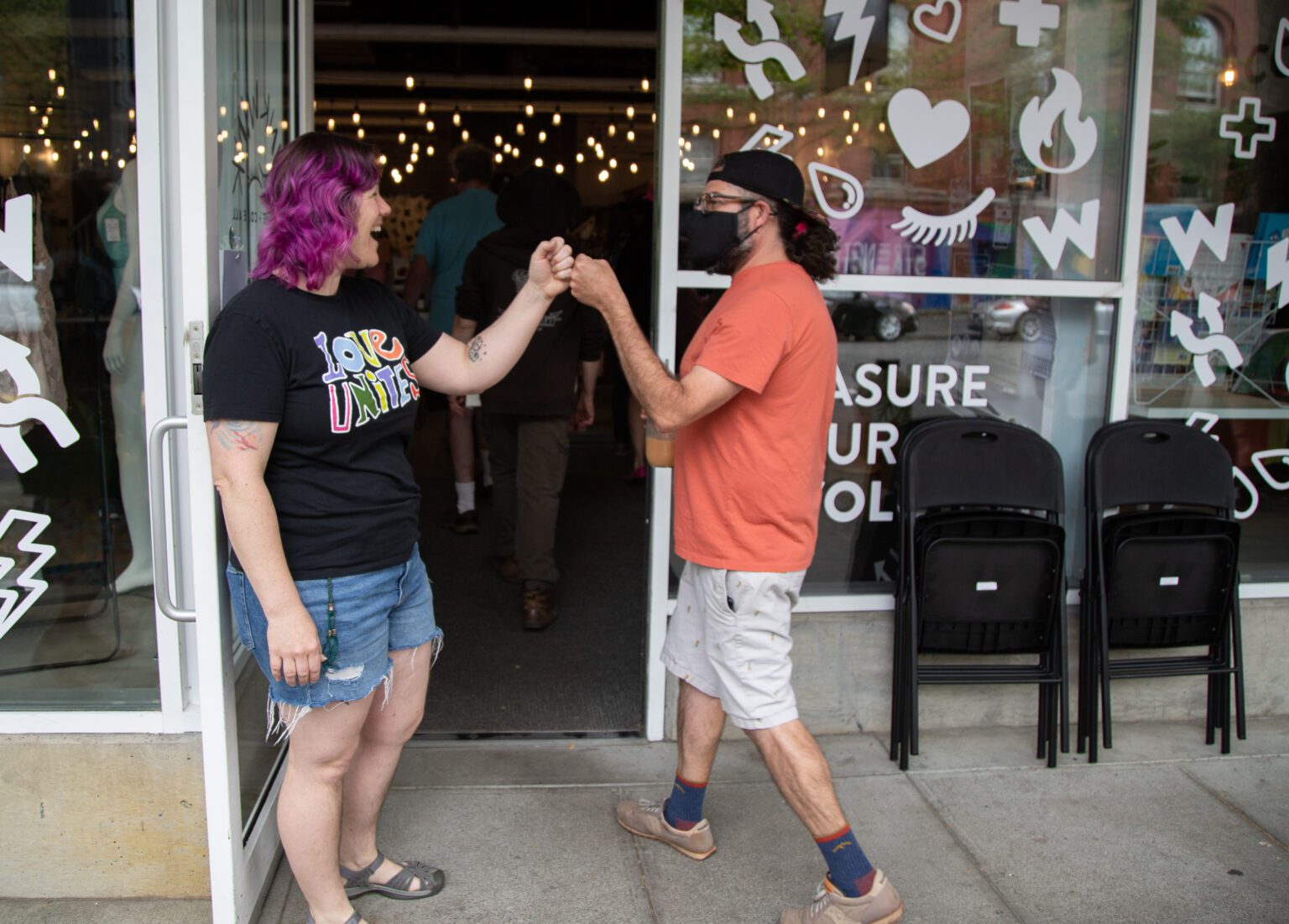 WinkWink Boutique employee Tiffany Geaudreau fist-bumps a supporter as they enter the store on July 8. The local sex shop expected protesters in response to its sex education course "Uncringe Academy" for 9- to 12-year-olds and 13- to 17-year-olds. No protesters showed up