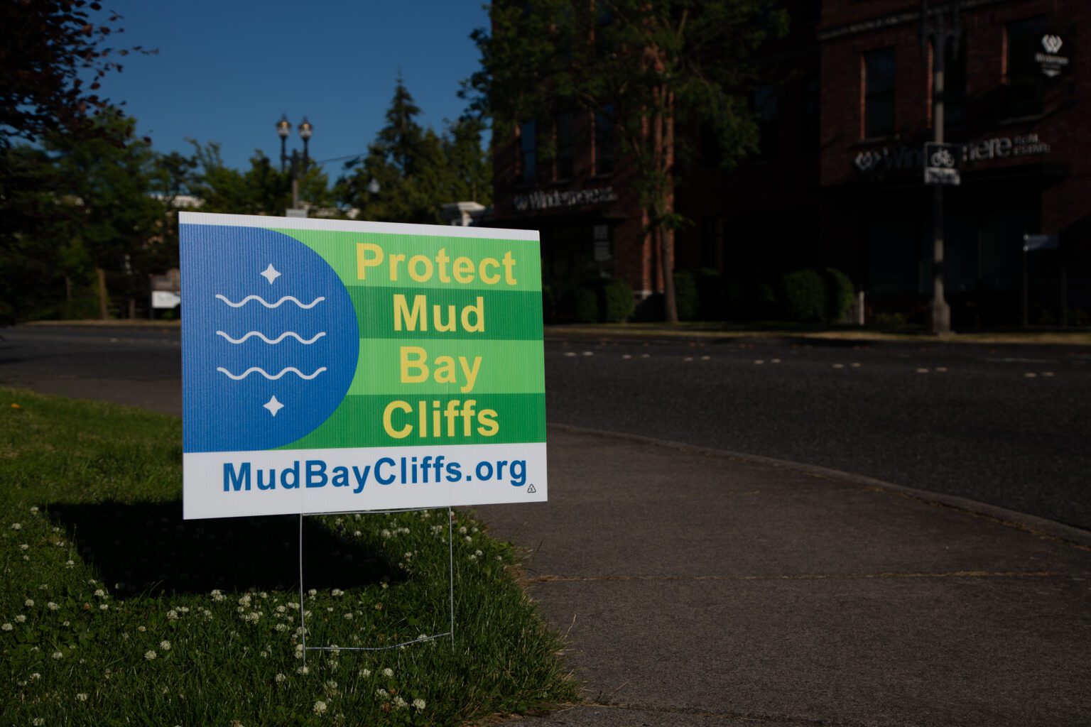A "Protect Mud Bay Cliffs" sign is posted in Fairhaven.