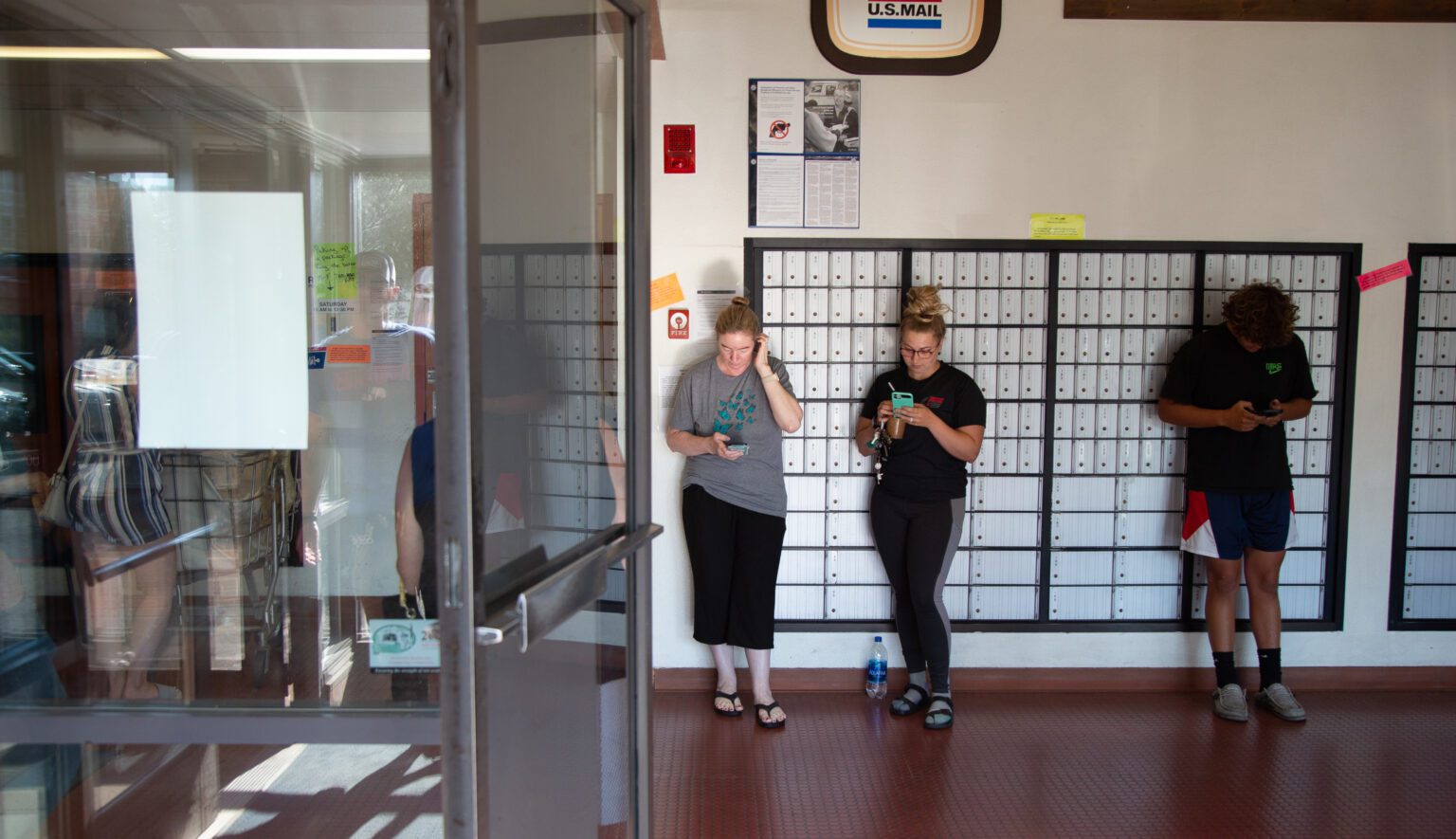 People wait in line to retrieve packages at the United States Postal Service in Ferndale on July 26.