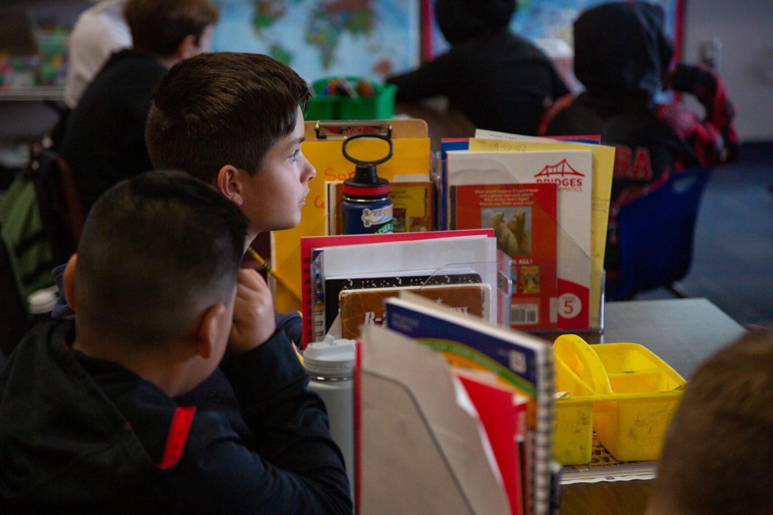 Students sit at desks at Northern Heights Elementary surrounded by their stationary and books stacked next to them.