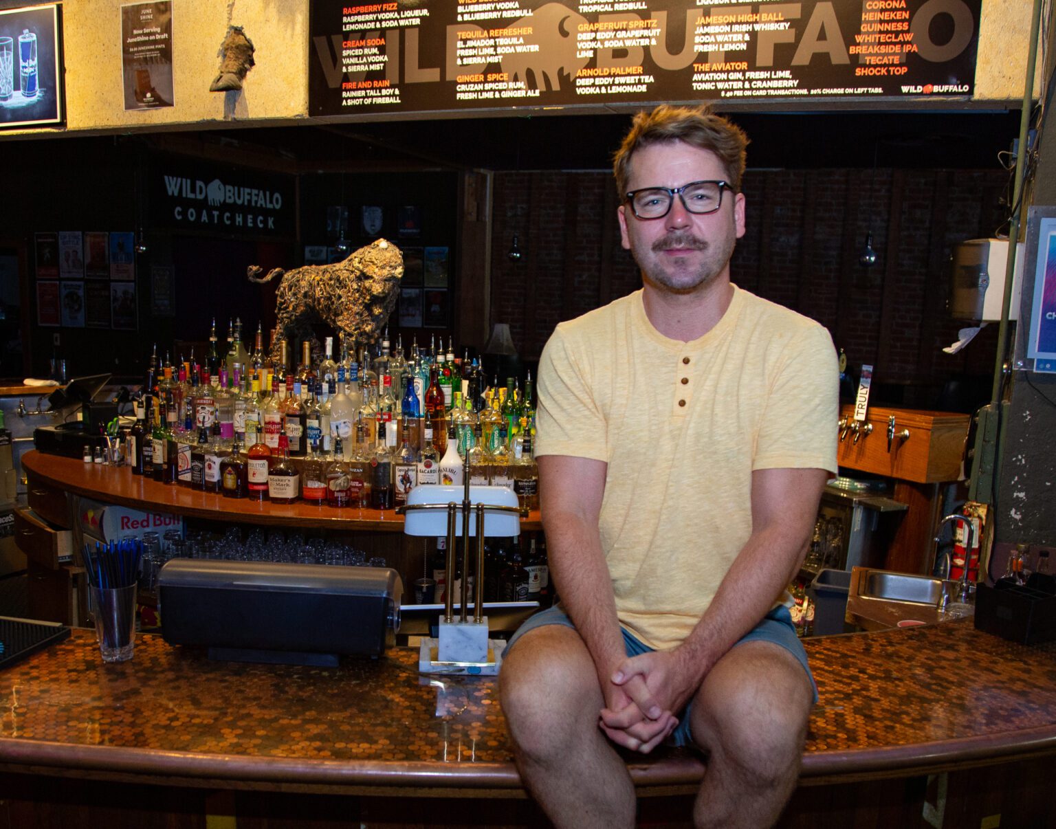 Craig Jewell sits on the bar counter at the Wild Buffalo in advance of the downtown Bellingham music venue's 25th-anniversary party with Polyrhythmics and Magic Beard Store