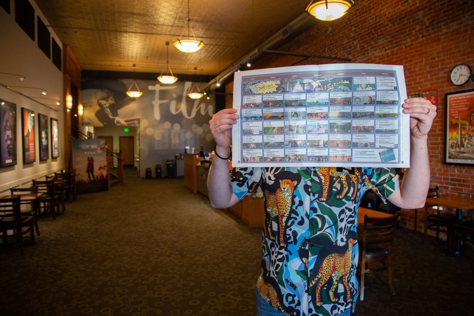 Projectionist Skyler Hunt holds the Doctober schedule up in the lobby of the Pickford Film Center on Sept. 25. Doctober begins Friday