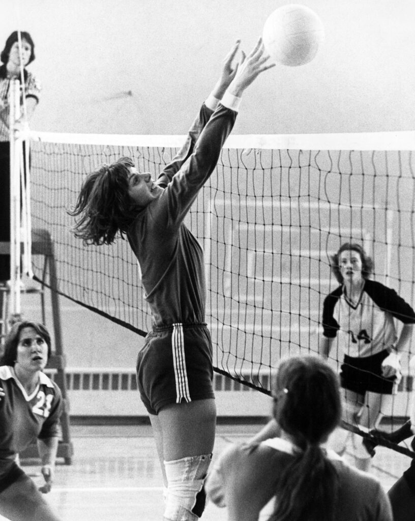 A vintage photo of Wendy Wefer hitting the ball over the net.