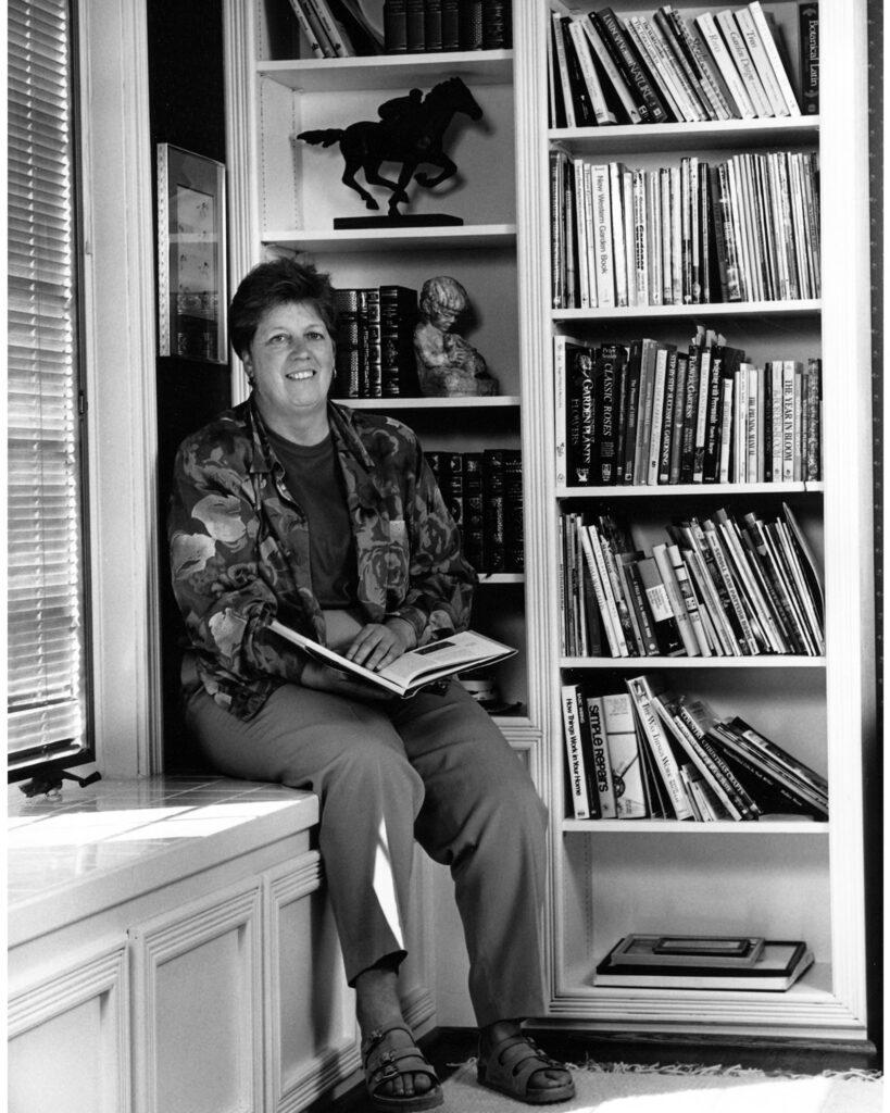 Lynda Goodrich sitting next to shelves of books.