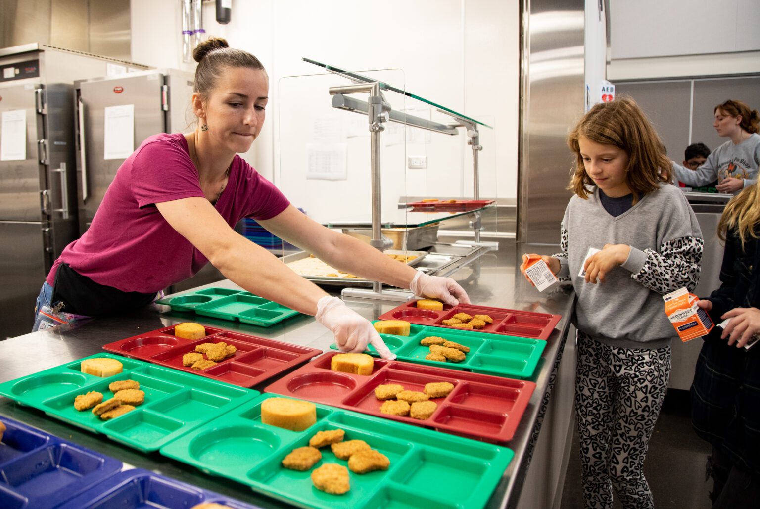 Food service assistant Jessica Johnson hands out trays of chicken nuggets and garlic bread for students at Alderwood Elementary School on Oct. 17. All students at Alderwood and at 13 other Bellingham schools receive free lunches under the Community Eligibility Provision through the USDA.