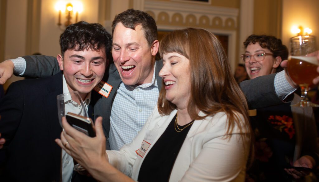 Joe Timmons, center reacts to preliminary election results with his arms around his campaign manager and his wife.