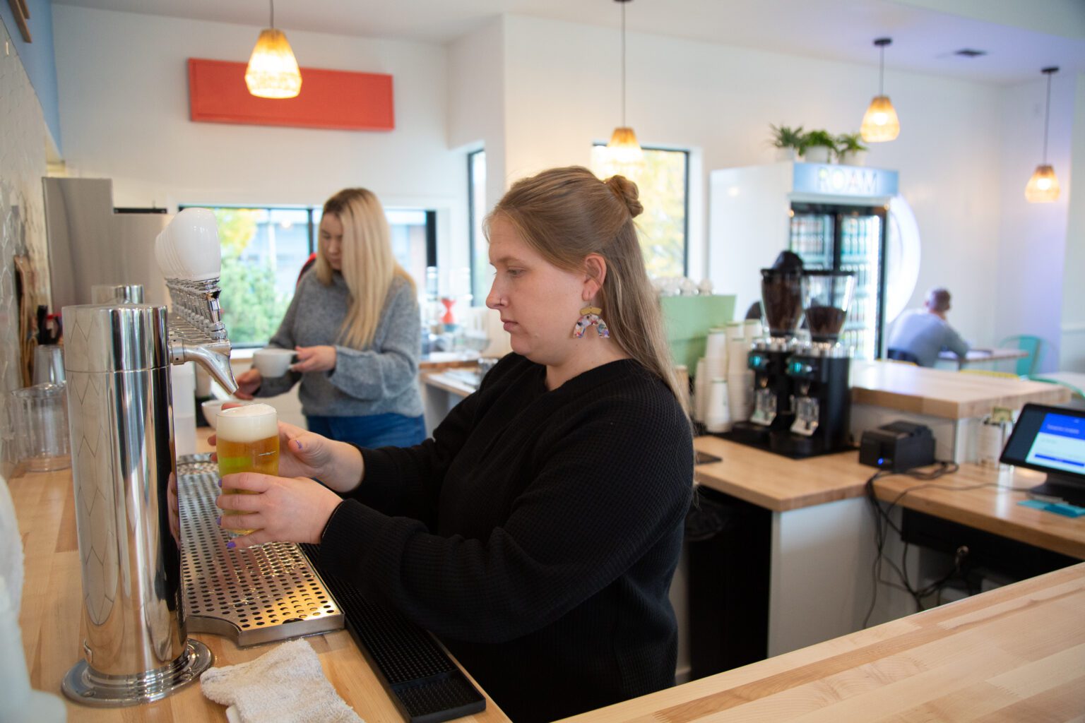 Moniece Mueller pours a beer at ROAM Coffee + Beer on Nov. 11. The new cafe