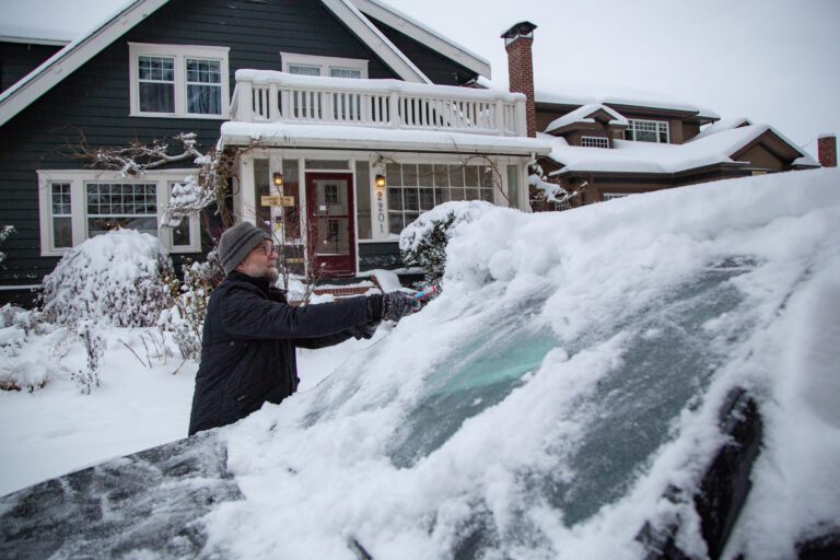 Andy Forrest wipes snow off his car before heading to his shop
