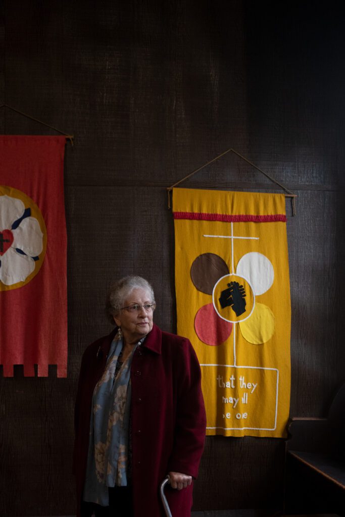 Ruth Hunt standing next to a church banner.