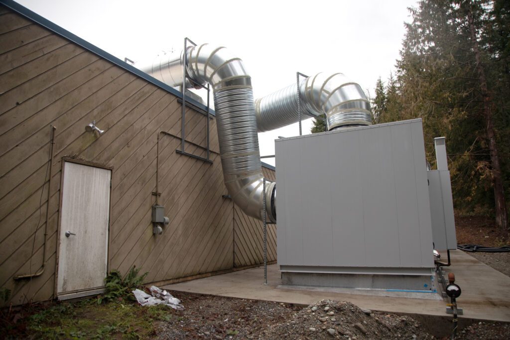 A large HVAC system with large tubes leading into the building.