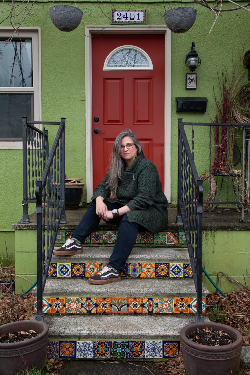 Janet Marino sits on the steps of her Bellingham porch Feb. 17. Behind her are bushels of yard scraps