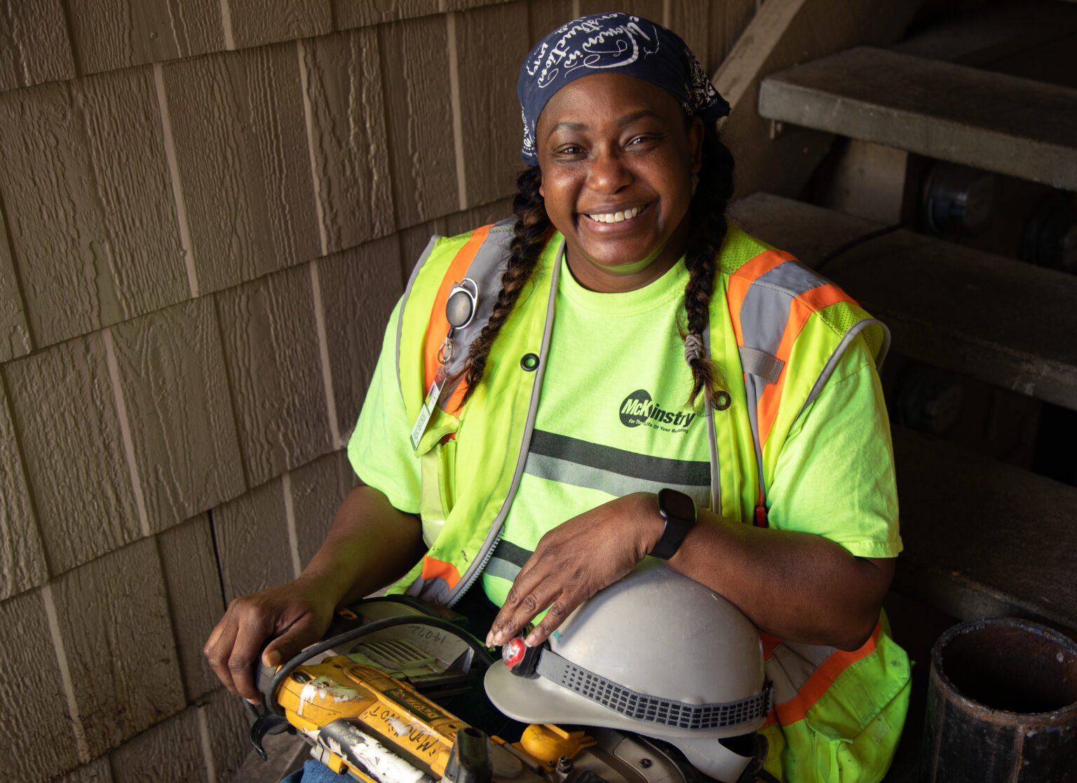 Curtistine Billups wearing a safety vest and holding her tools and helmet.