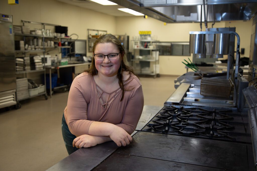 Meridian High School junior Lexi Garvin leaning against ovens and burners.