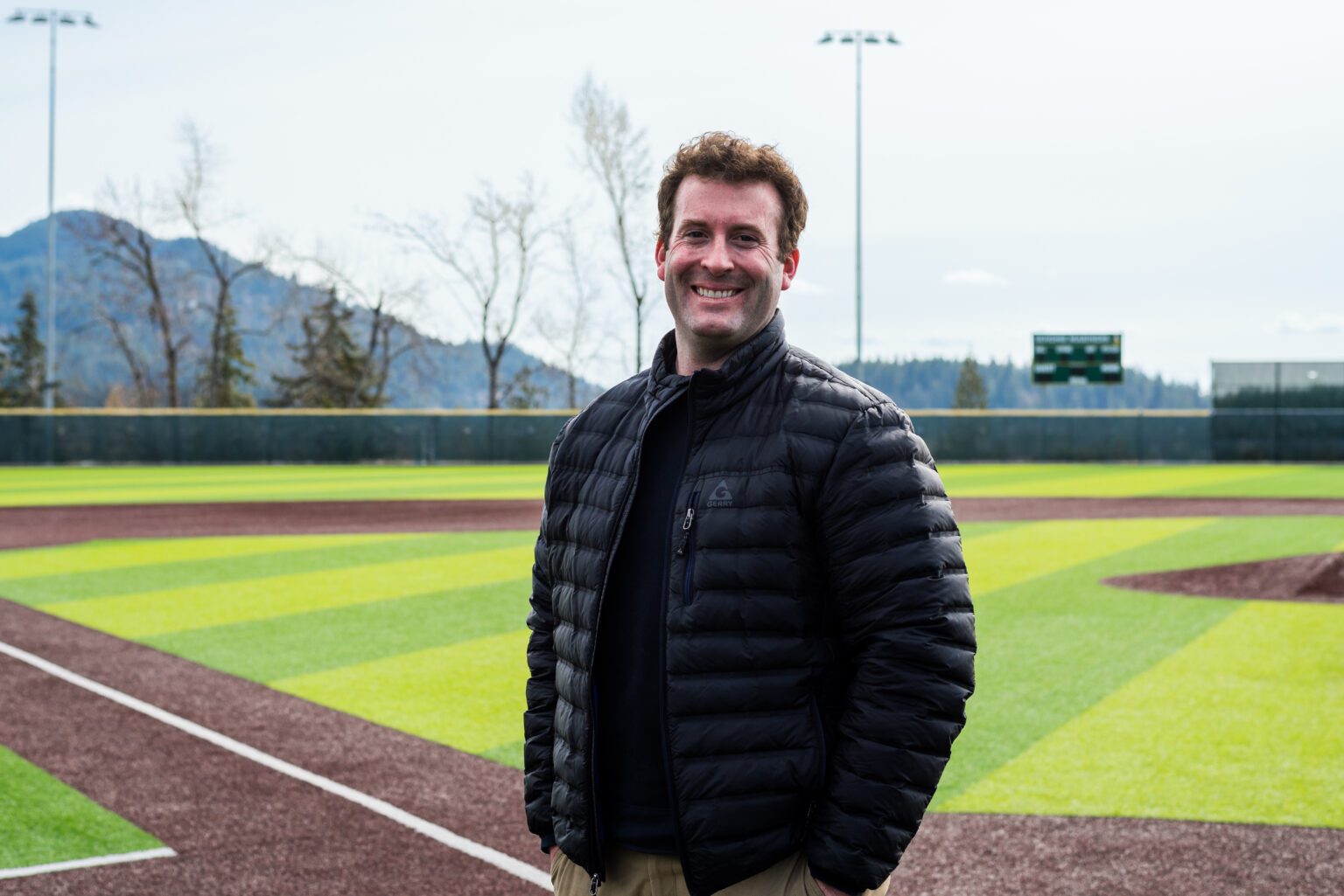 Dane Siegfried stands on the baseball field at Sehome High School with the grassy fields behind him.