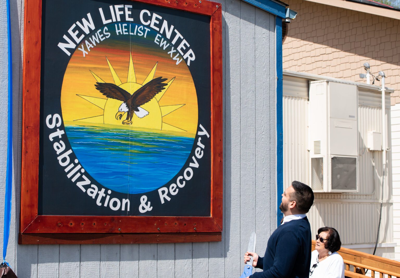 Lummi Indian Business Council Chairman Anthony Hillaire and Rosalie Scott look up at the colorful sign for the New Life Center.
