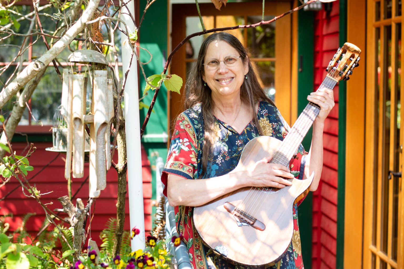 Fl!p Breskin holds her guitar in her backyard. When she moved to the Columbia neighborhood in 1999