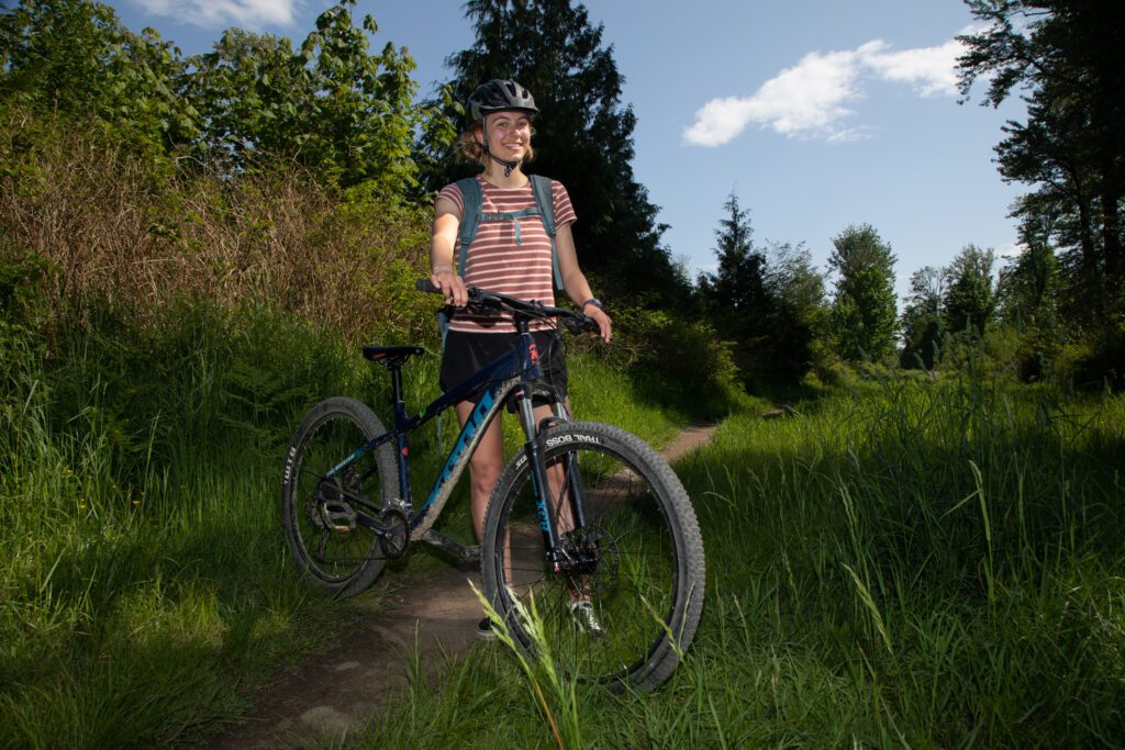 Olivia Palmer stands on Pipeline Road with her mountain bike.