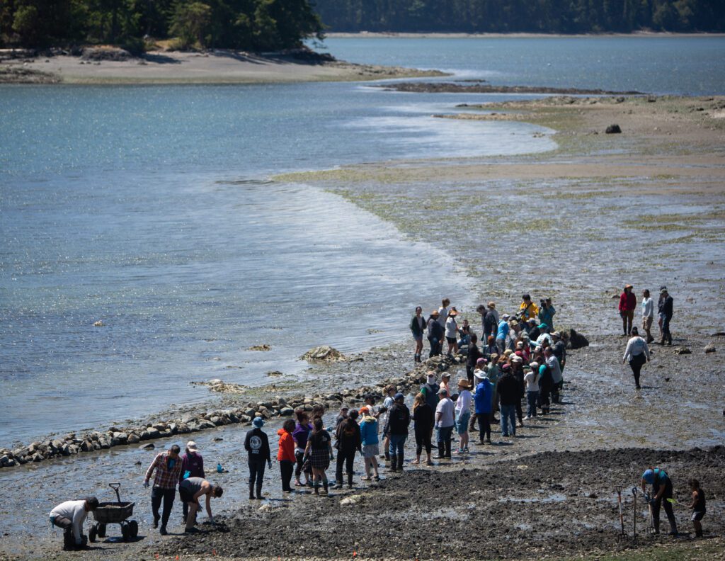 Participants of the Salish Summit stand by the makeshift wall of rocks.