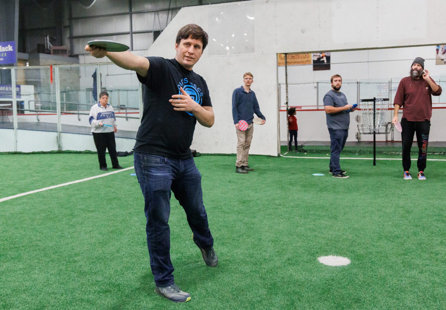 Jason Einfeld describes the proper body and arm positioning for throwing during a disc golf class at the Sportsplex on Jan. 13. The class