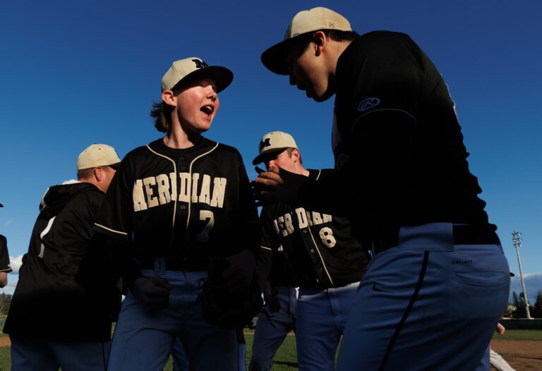 Meridian pitcher Jonah Aase (7) celebrates with teammates after a 4-3 win over Lynden on March 31.