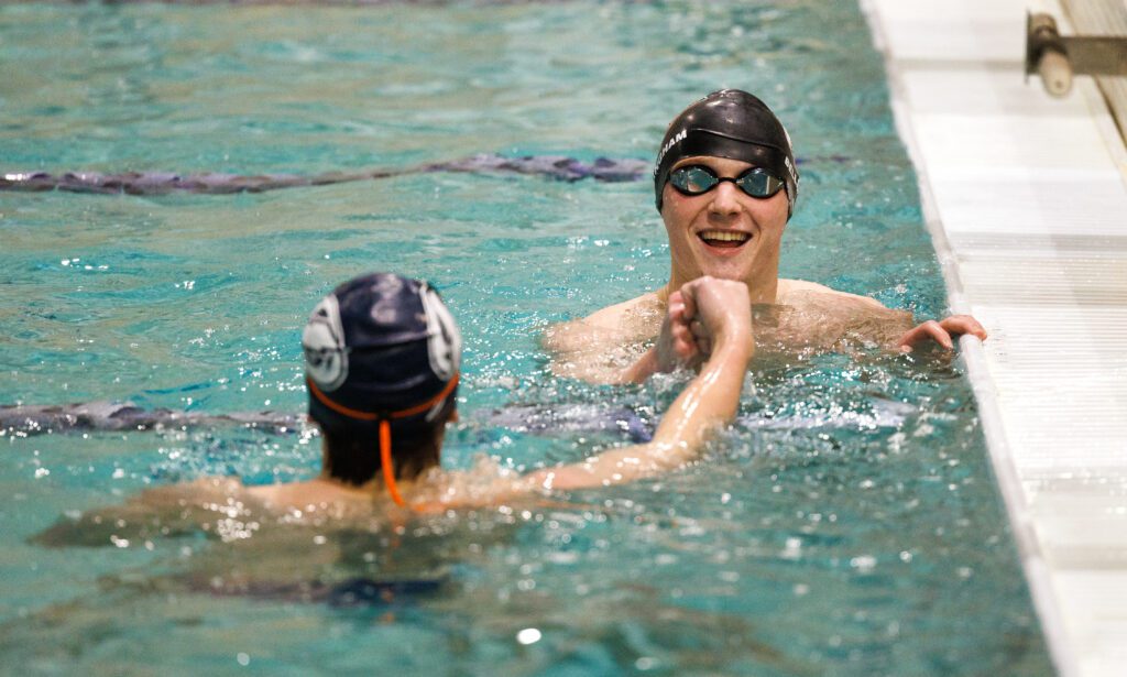 Bellingham’s Miles Cratsenberg and Squalicum’s Dylan Fisk fist-bump in the pool.