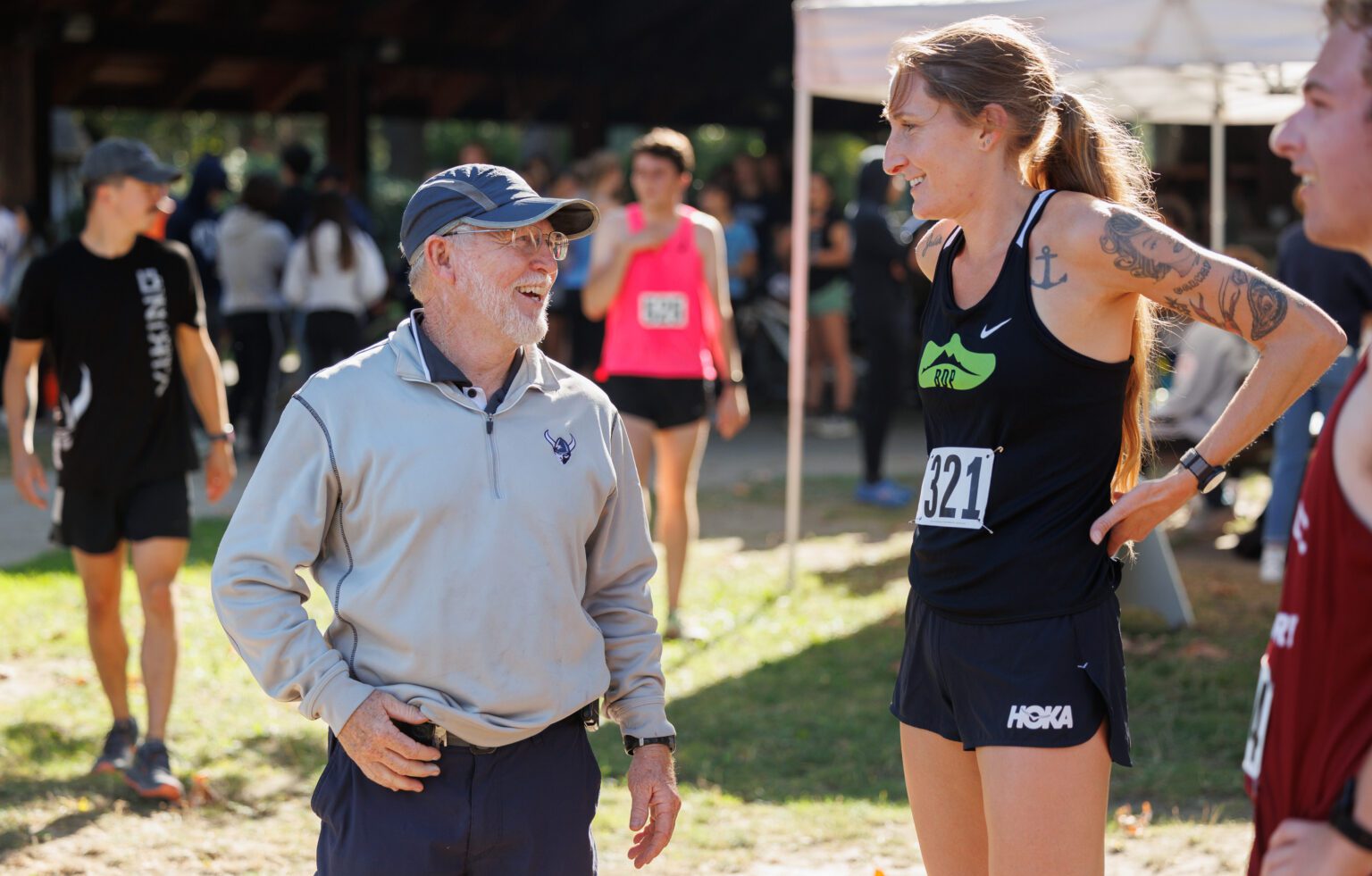 Western Washington University cross country head coach Pee Wee Halsell laughs with former Western runner Courtney Olsen before the women’s race of the Bill Roe Classic on Sept. 24