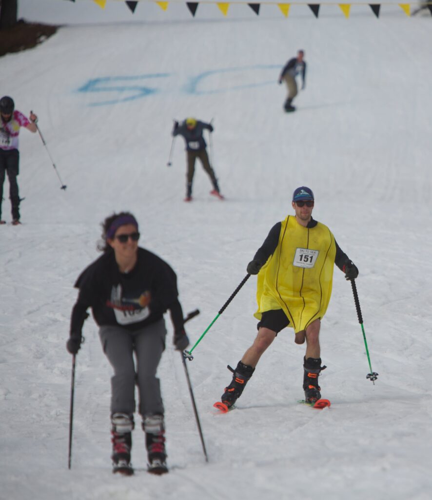 Kevin Monroe dressed up as a banana trails behind another skier.