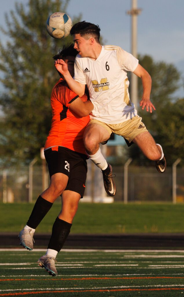 Meridian's Kellen Todd runs into Blaine's Joel Barrientos-Estrada as he leaps to headbutt the soccer ball.
