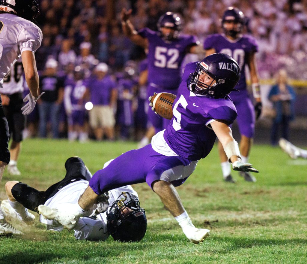 Nooksack Valley’s Skyler Whittern spins in for a touchdown as grass flies up due to the scuffle between him and the other opposing player.